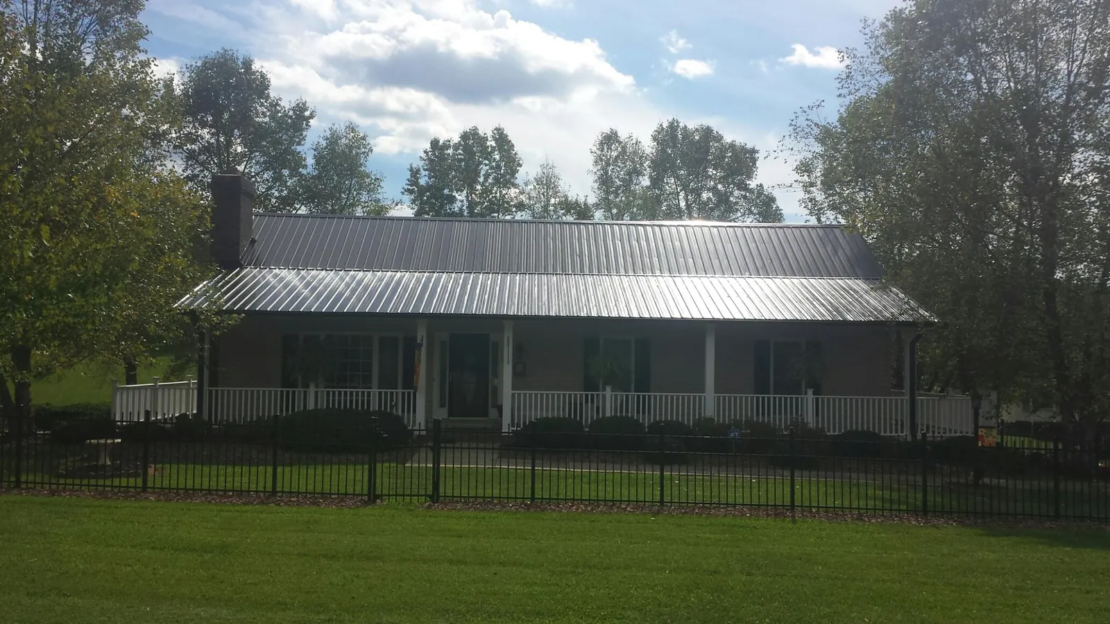Gray metal roof on a brick ranch with a full width front porch — Gutter Guard Installation work by our crew in Hamtramck